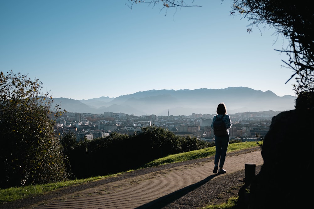 a person standing on a hill overlooking a city