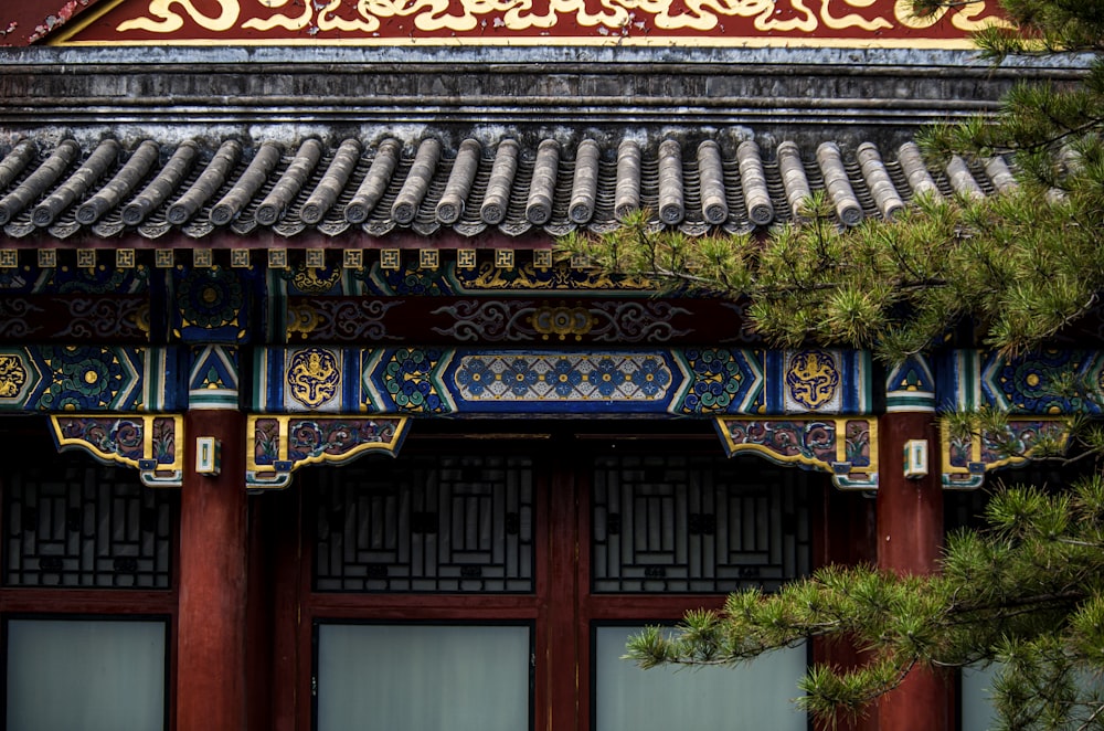 a building with a red door and a green tree