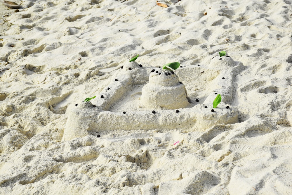 Un château de sable fait pour ressembler à un bonhomme de neige