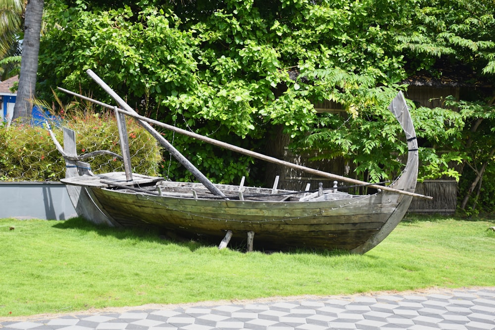 a boat sitting on top of a lush green field