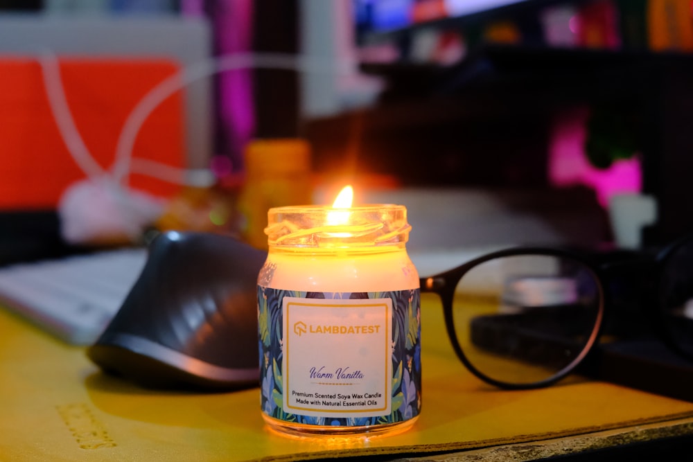 a lit candle sitting on top of a desk