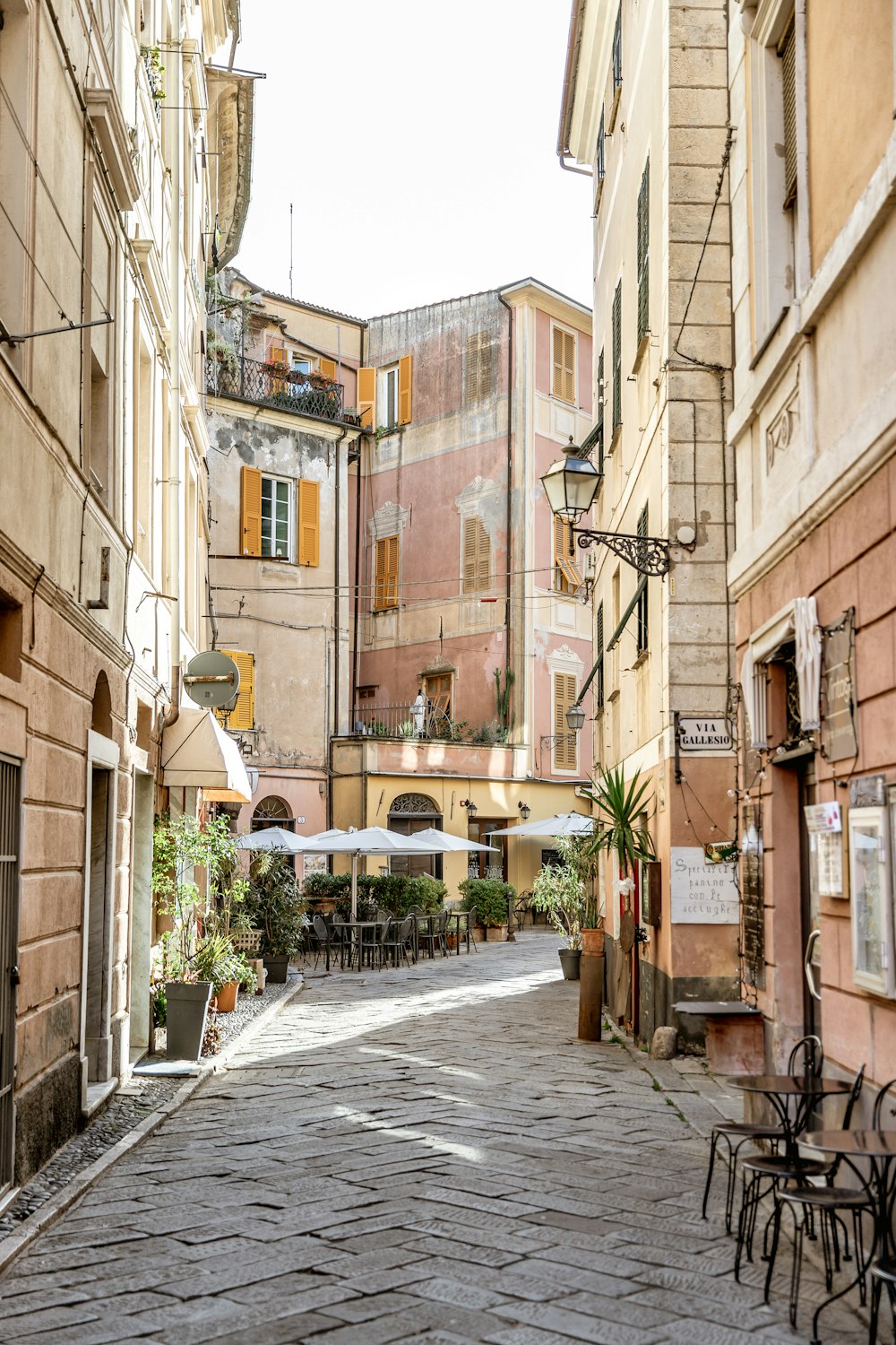 a cobblestone street lined with tables and chairs