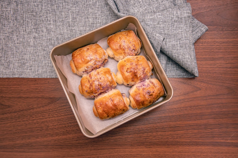 a pan filled with pastries sitting on top of a wooden table
