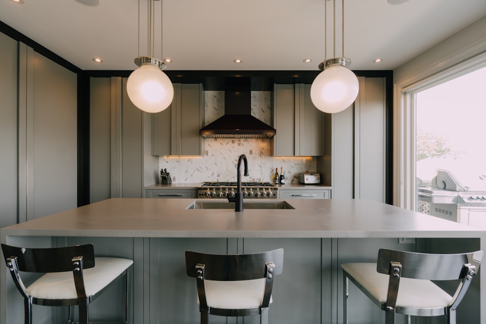 a kitchen with a center island and three chairs