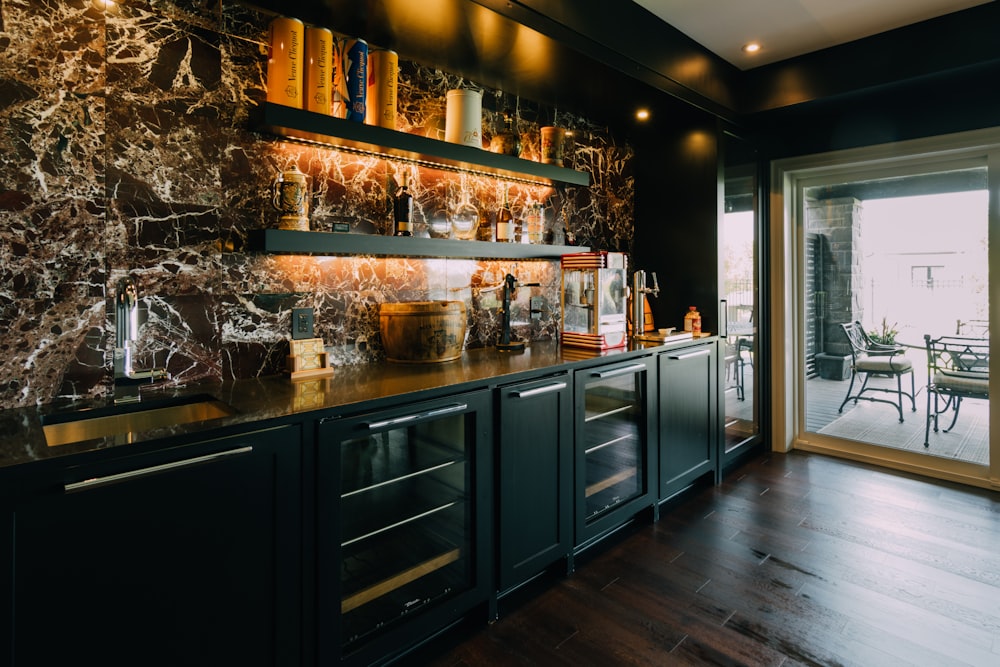 a kitchen with a marble wall and wooden floors