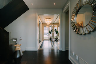 a hallway with a large mirror and a chandelier