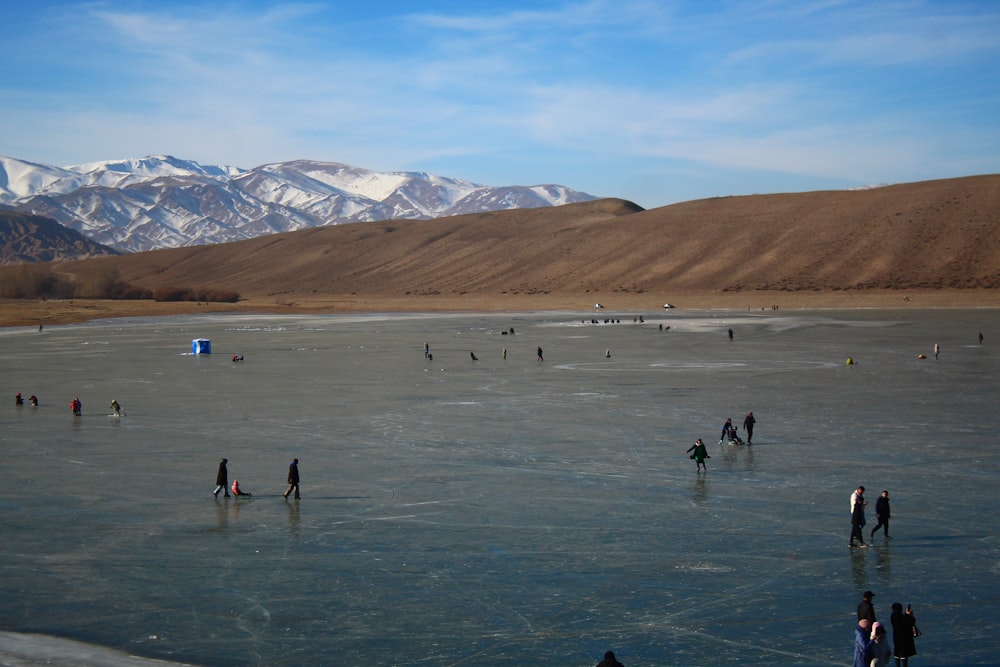 a group of people standing on top of a frozen lake