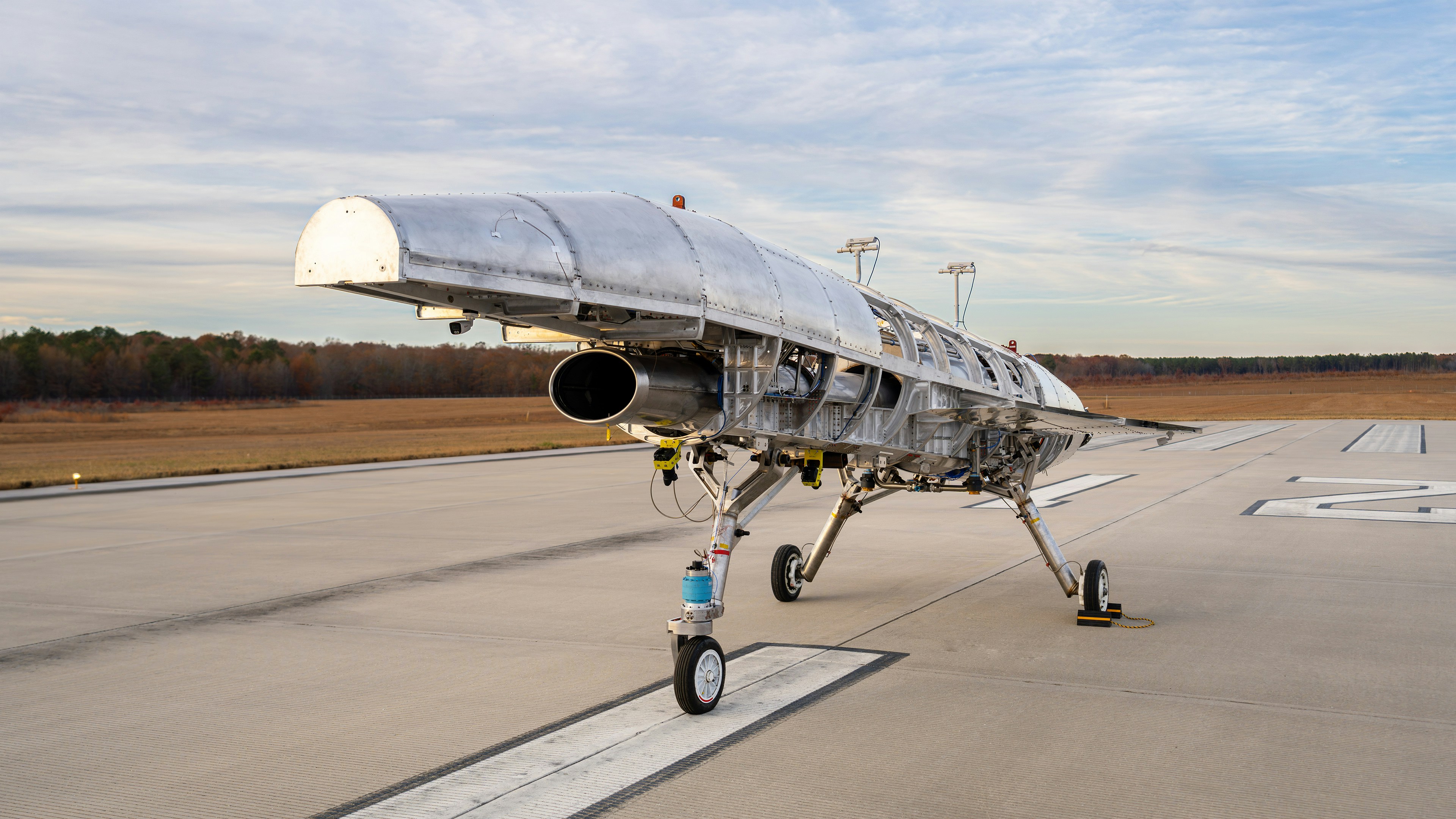 a silver airplane sitting on top of an airport tarmac