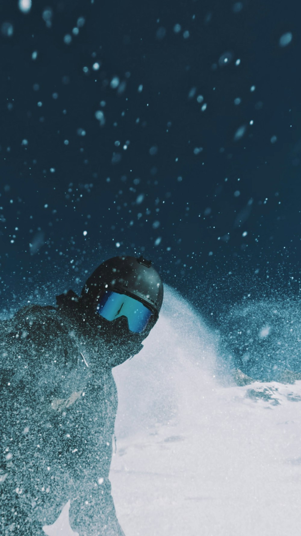 a man riding a snowboard down a snow covered slope