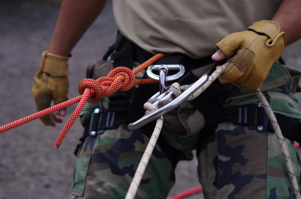 a man holding a rope and a pair of scissors