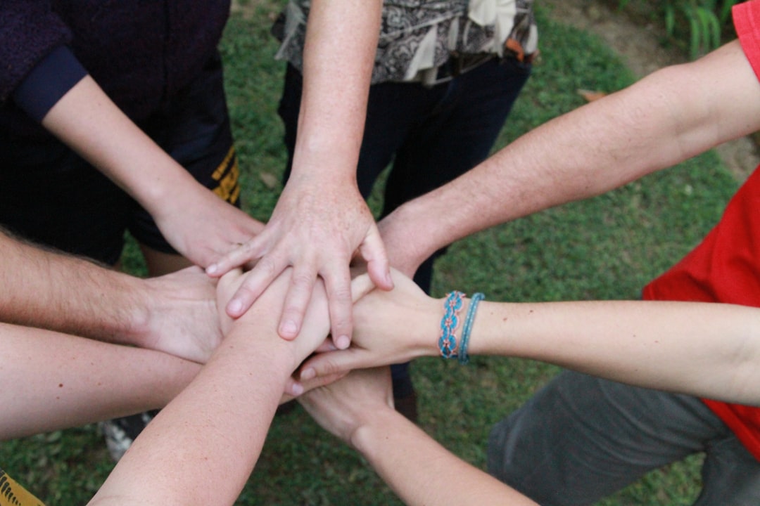 a group of people putting their hands together,