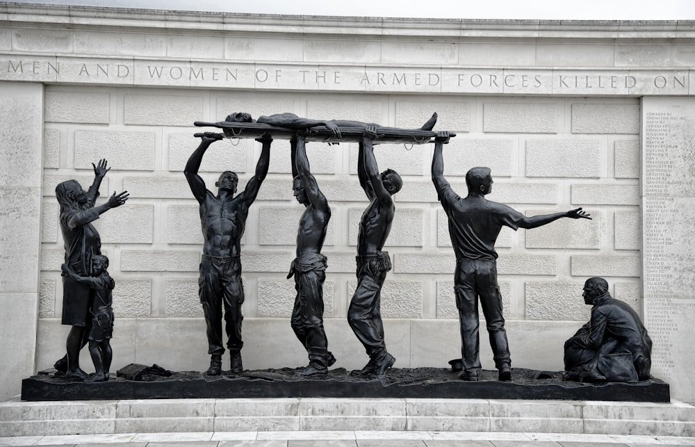 a statue of a group of men lifting a piece of wood