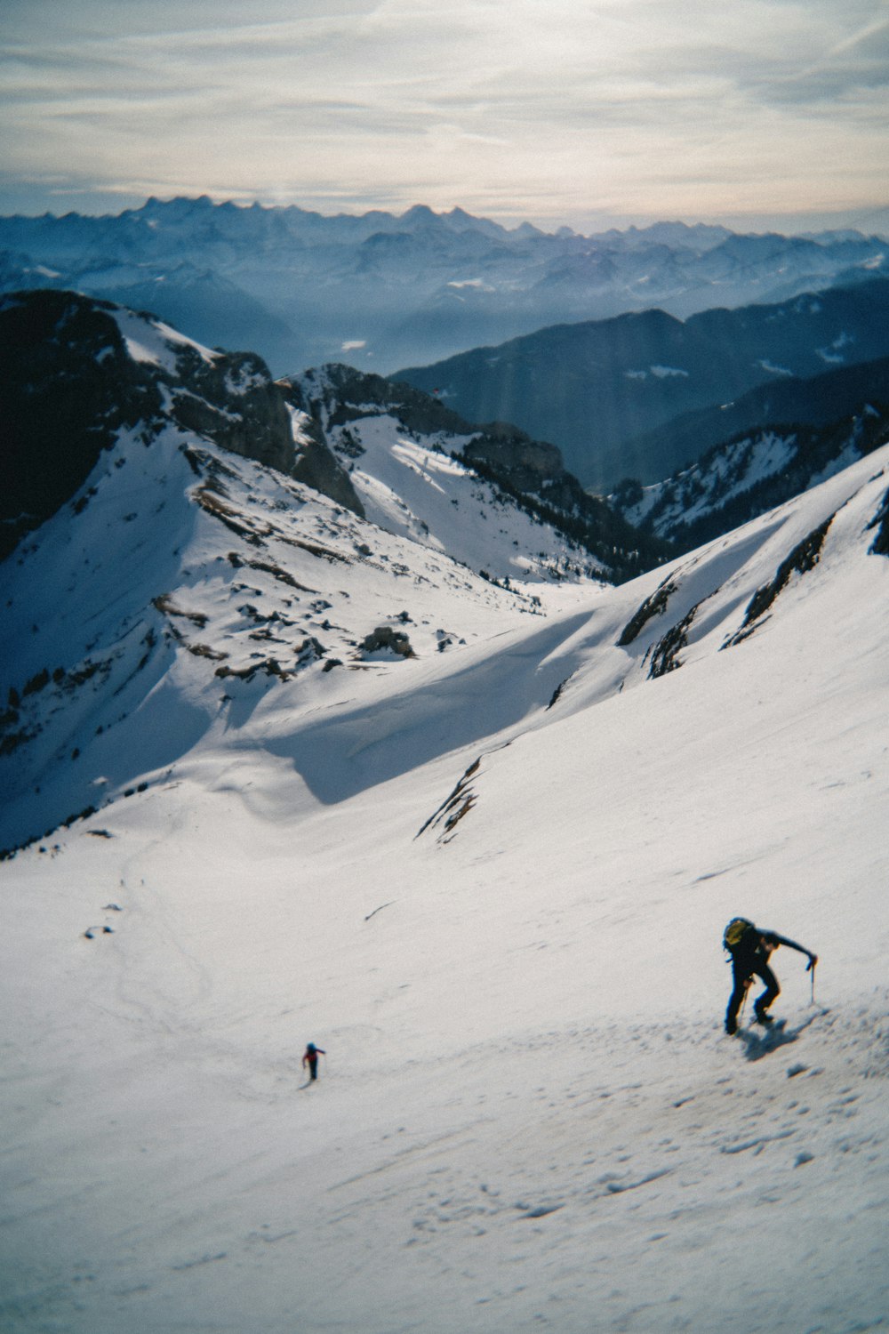a man riding skis down the side of a snow covered slope