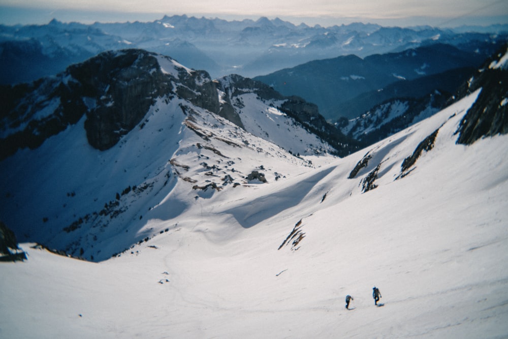 a group of people riding skis down a snow covered slope