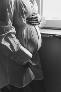 a pregnant woman standing in front of a window