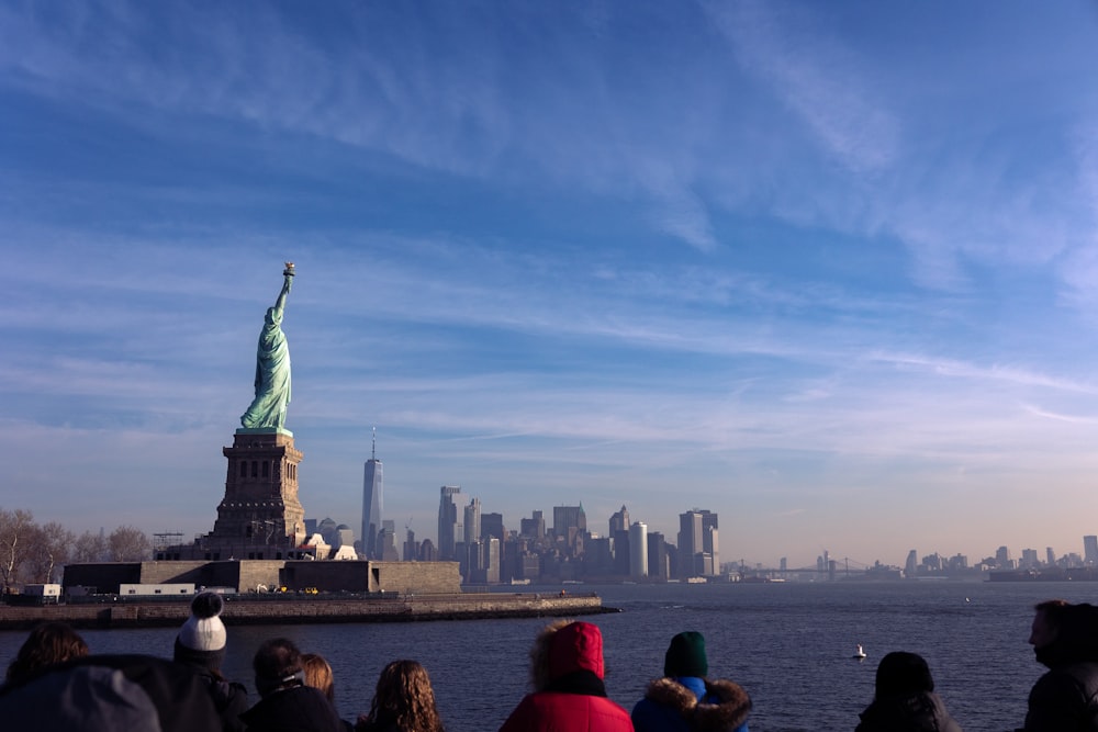 a group of people looking at the statue of liberty