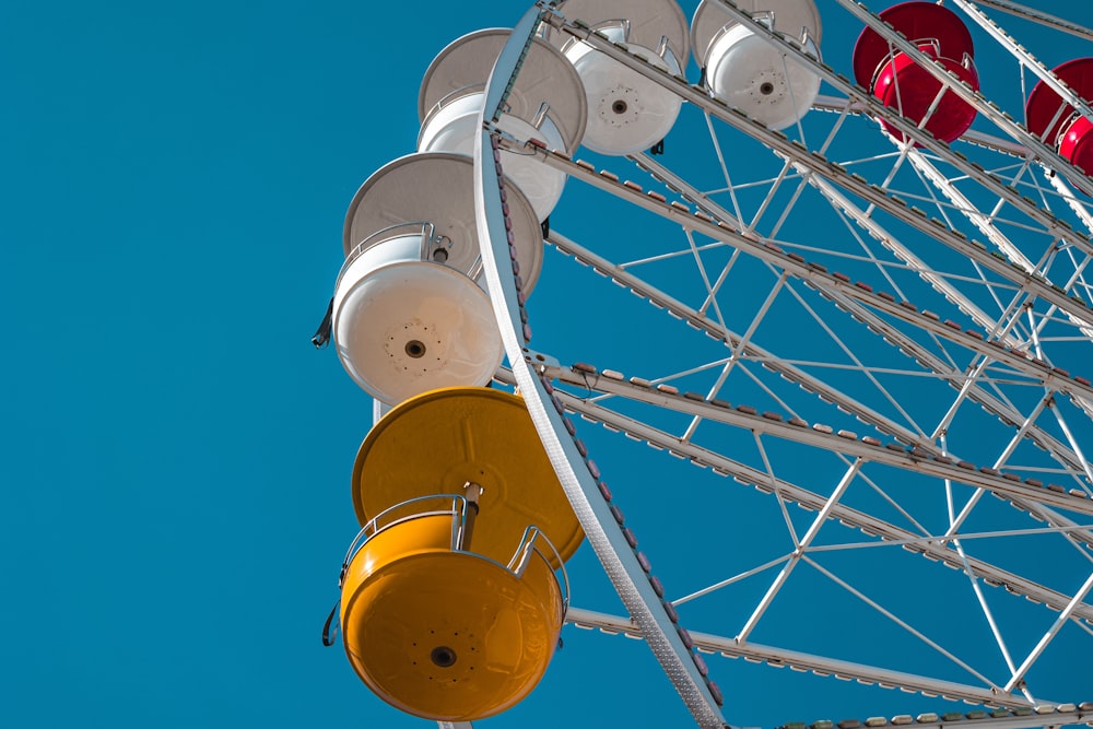 a ferris wheel with red and yellow lights against a blue sky