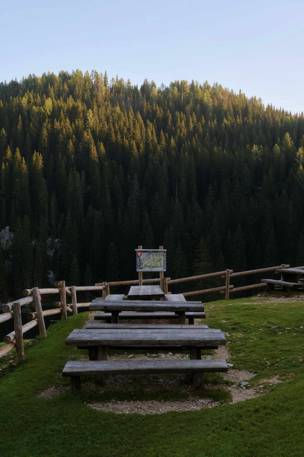 a wooden picnic table sitting on top of a lush green field