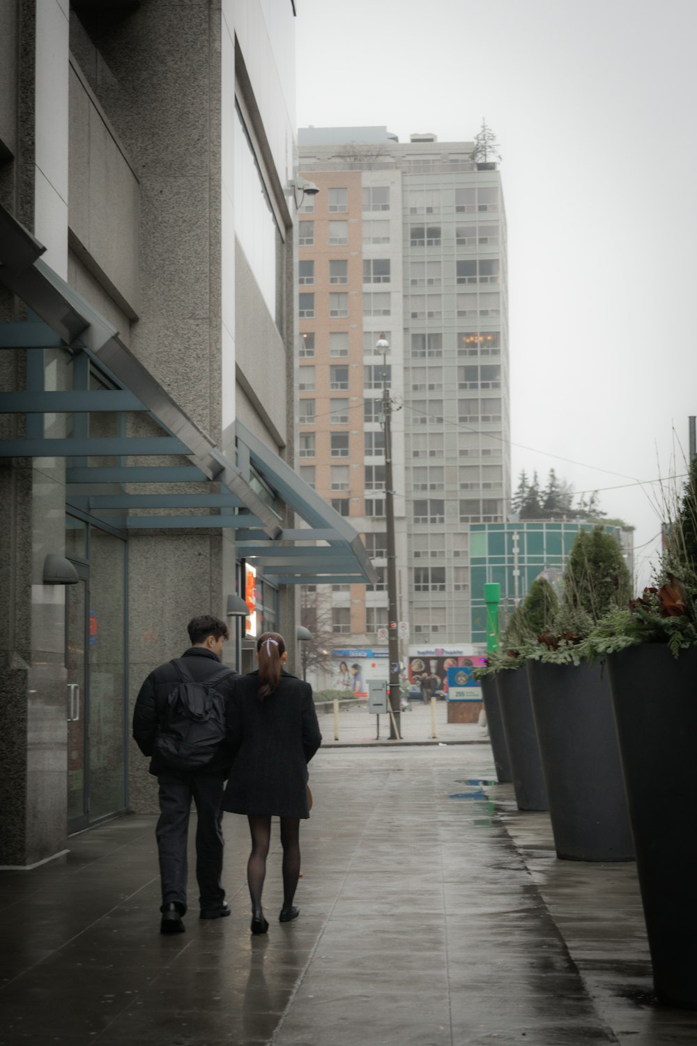 a man and a woman walking down a sidewalk