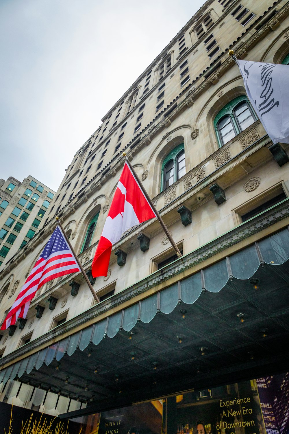 a group of flags hanging from the side of a building