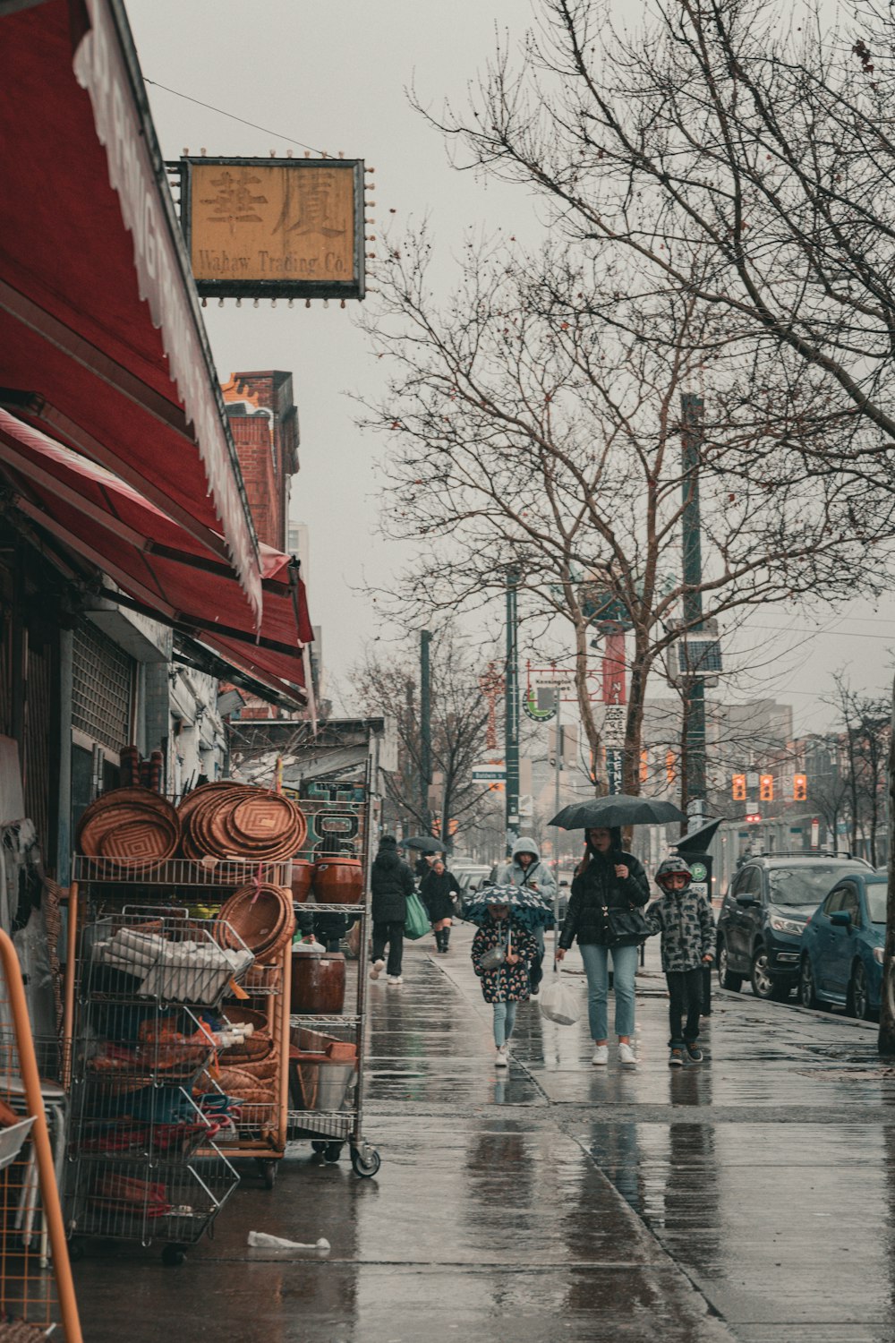 a group of people walking down a rain soaked street