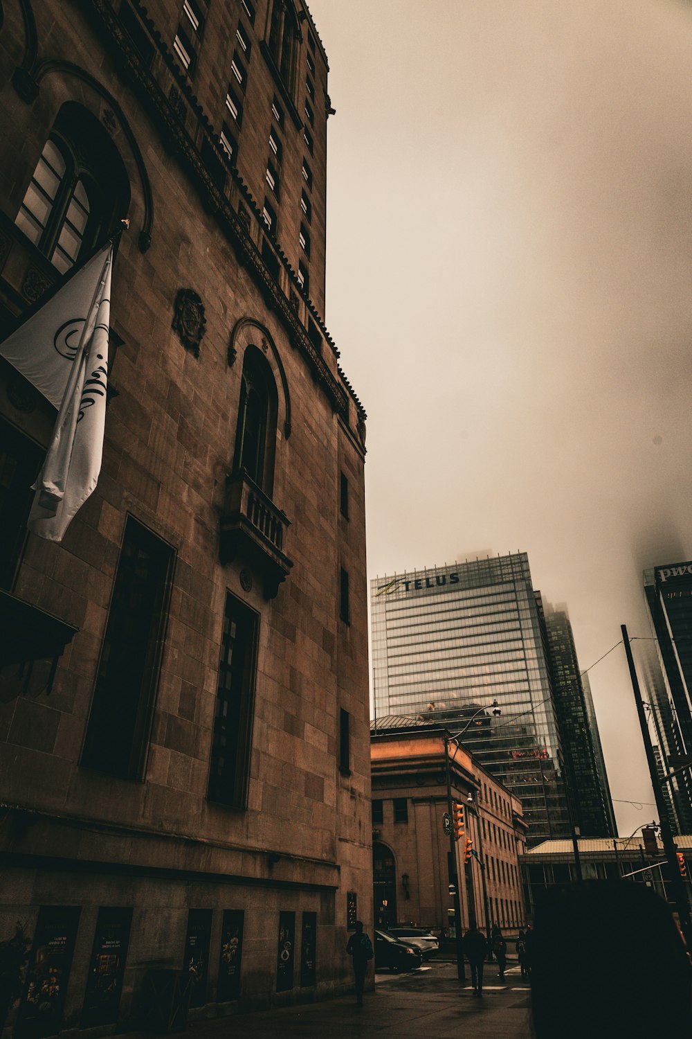 Un edificio alto de ladrillo con una bandera colgando de su costado