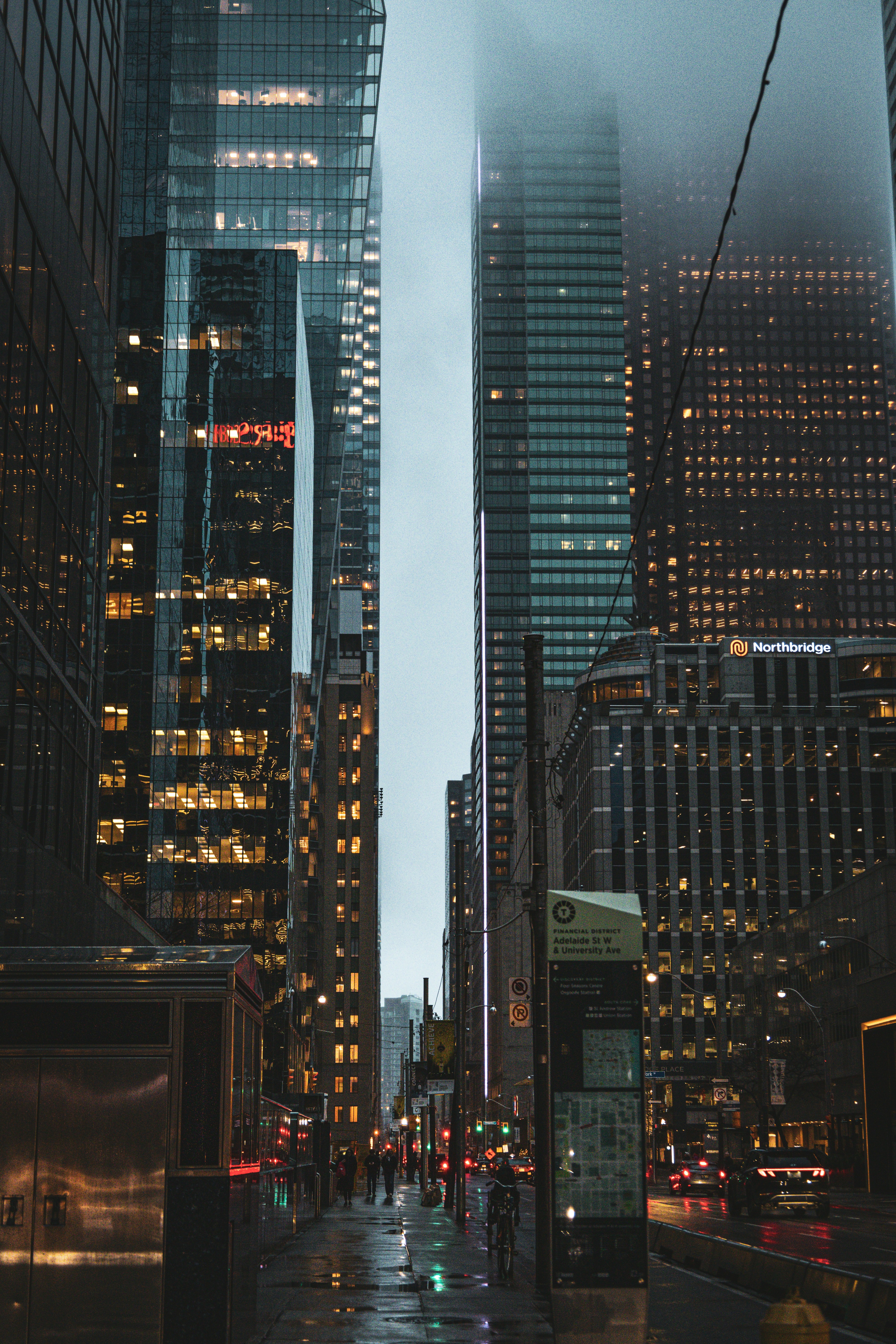 a city street at night with tall buildings