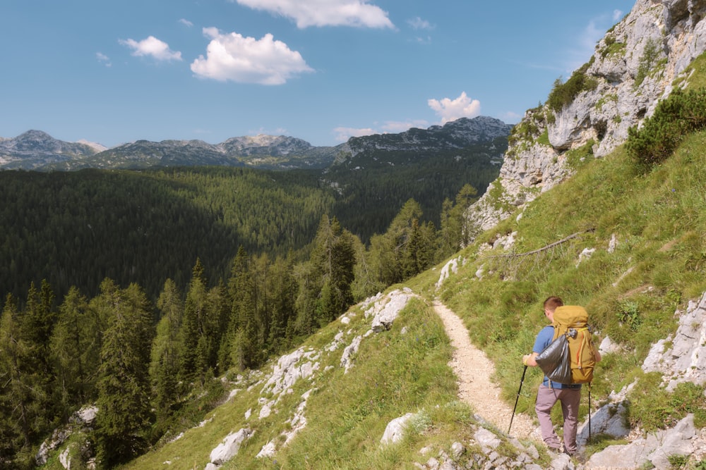 a man with a backpack hiking up a hill