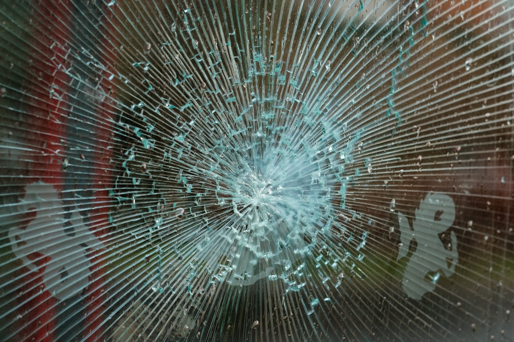 a broken glass window with people reflected in it