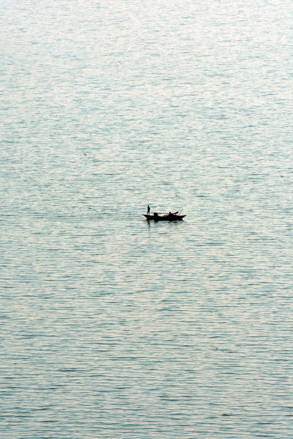 a person in a small boat on a large body of water