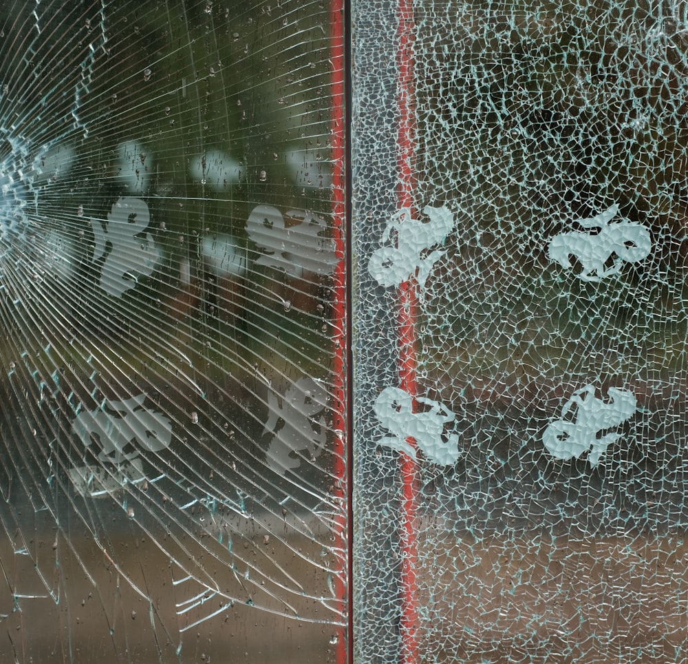 a broken glass window with white stickers on it