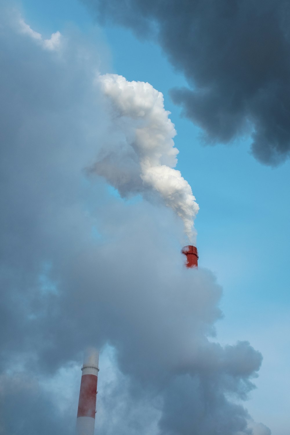 a smokestack emits from a factory chimney