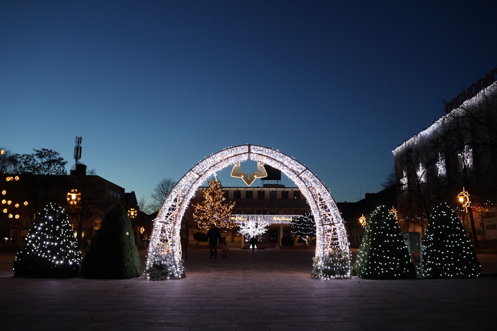 a lighted archway in the middle of a walkway