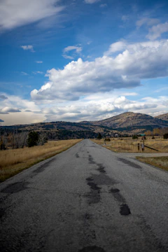 an empty road in the middle of a field