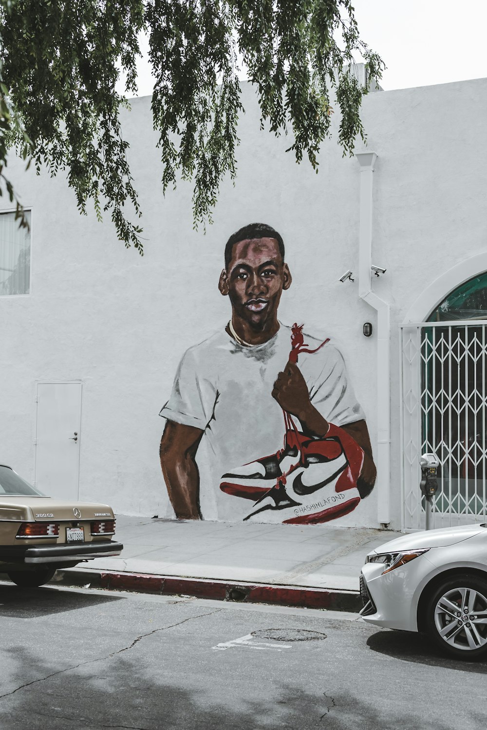 um mural de um homem com um tênis de basquete na lateral de um prédio