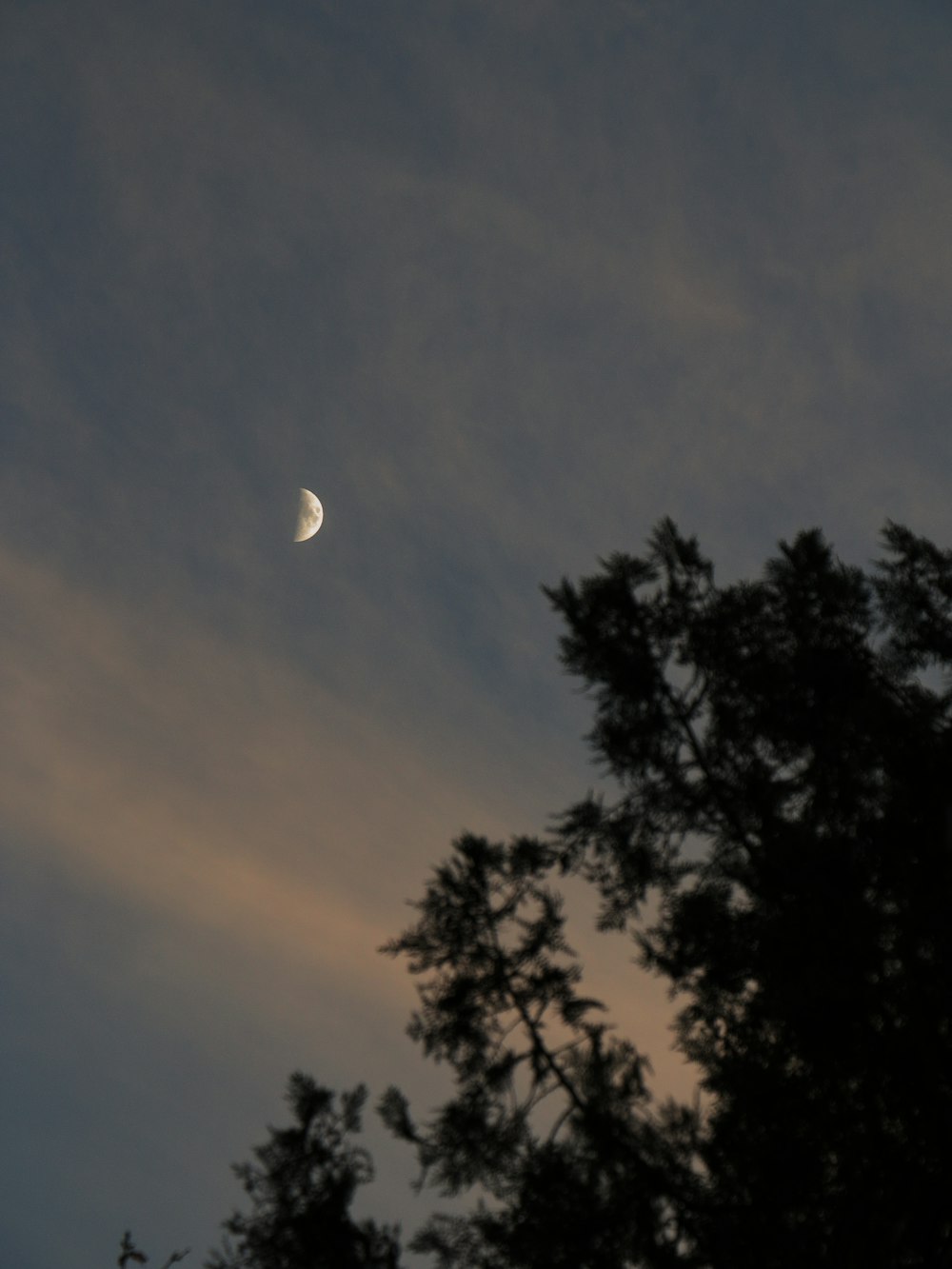 the moon is seen through the clouds in the sky