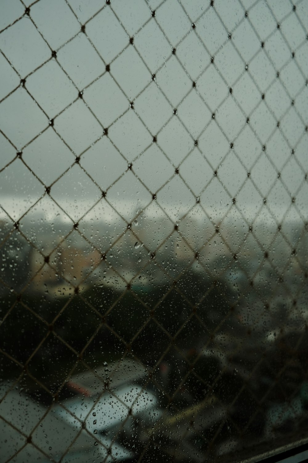 a view of a city through a chain link fence