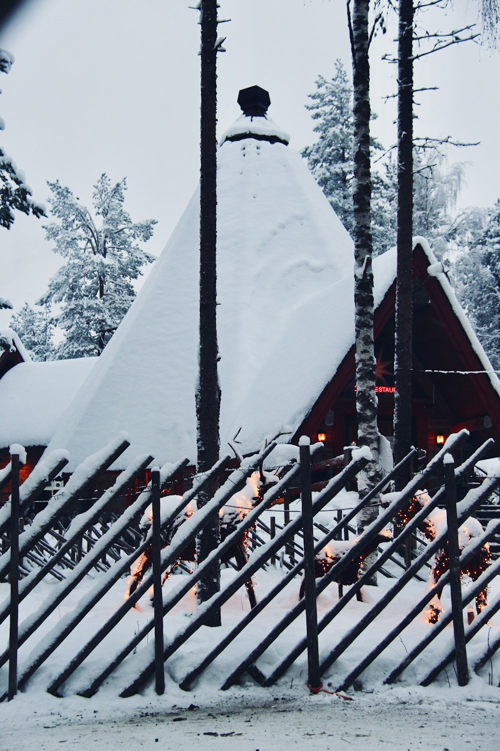 a pile of snow sitting on top of a wooden fence