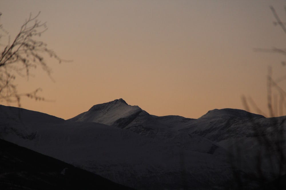 a view of a snowy mountain at sunset