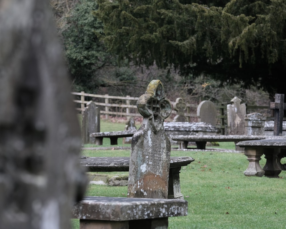 a cemetery with several stone benches in the grass