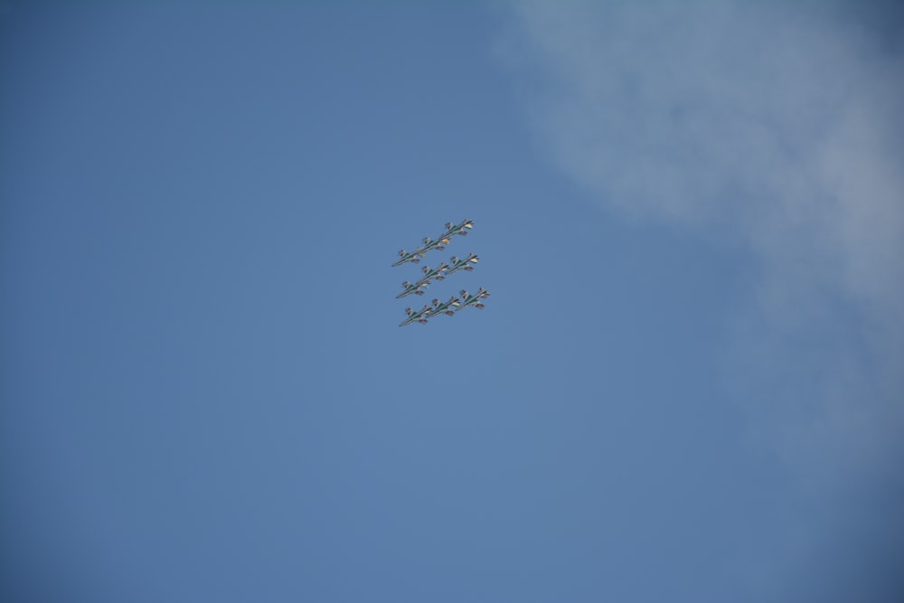 four airplanes flying in formation in a blue sky