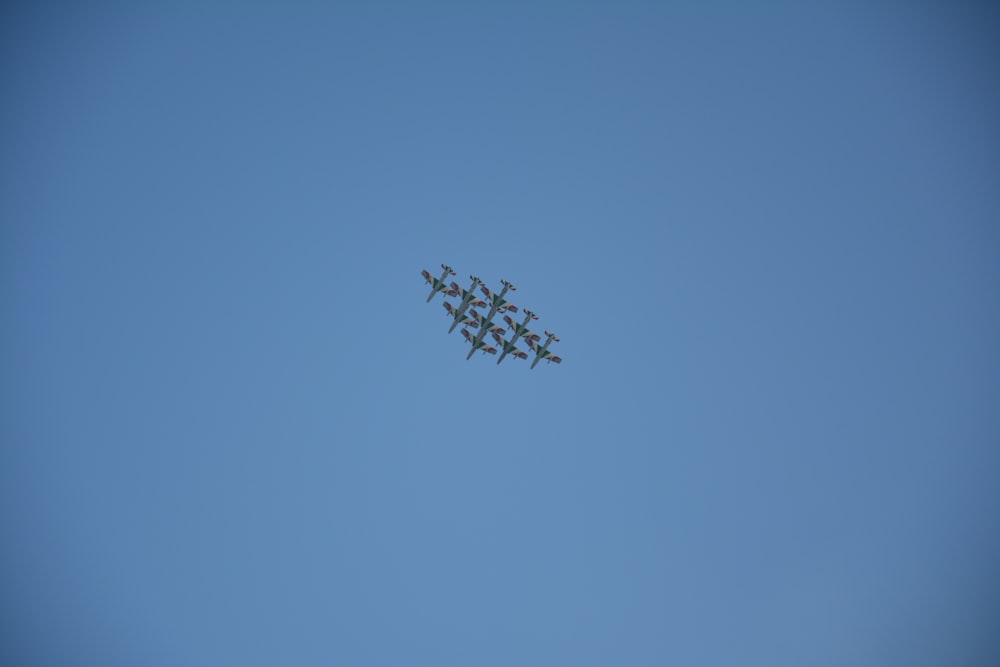 a formation of fighter jets flying through a blue sky