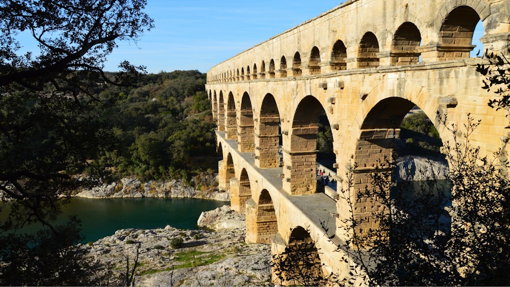 a stone bridge with arches over a body of water