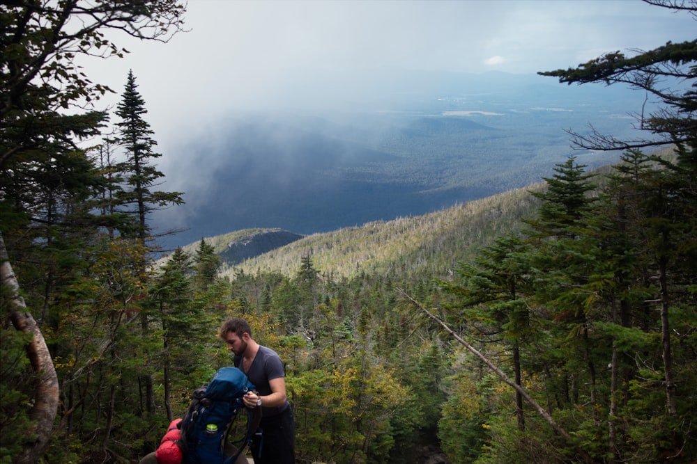 a man with a backpack standing on a mountain