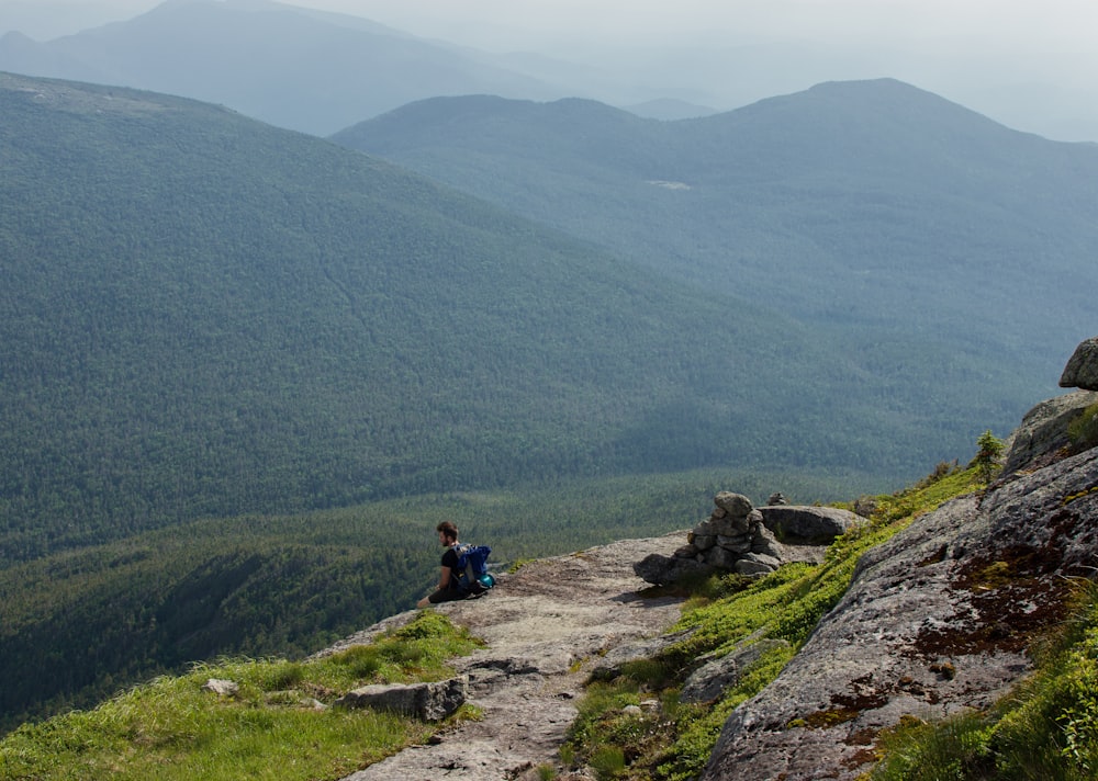 a person sitting on top of a mountain