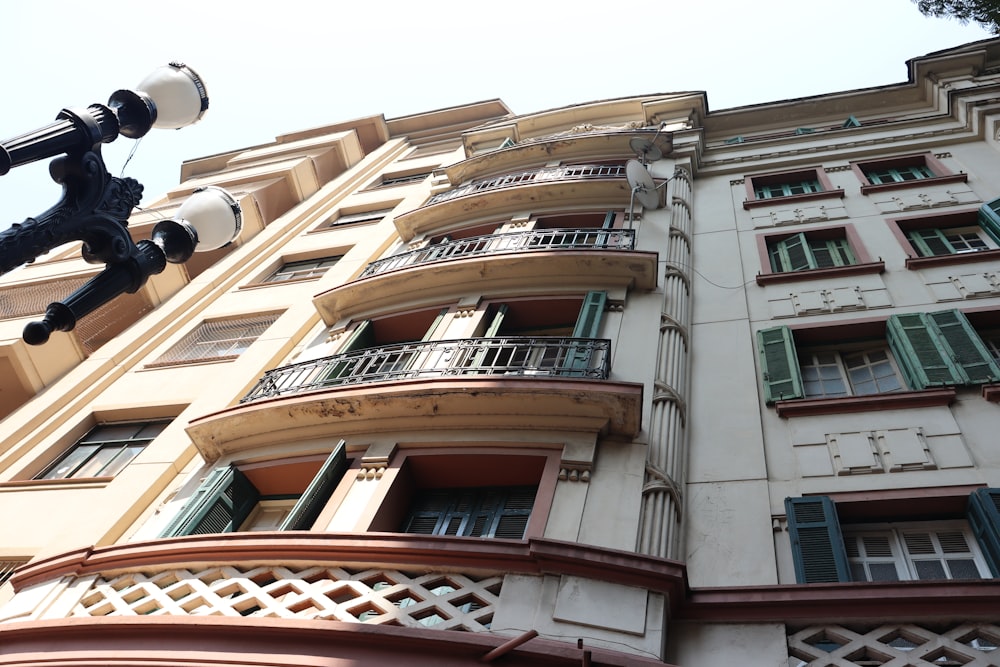 a tall building with balconies and green shutters