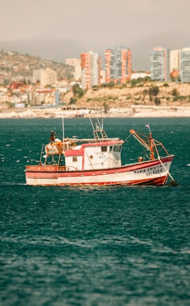 a red and white boat in the middle of the ocean