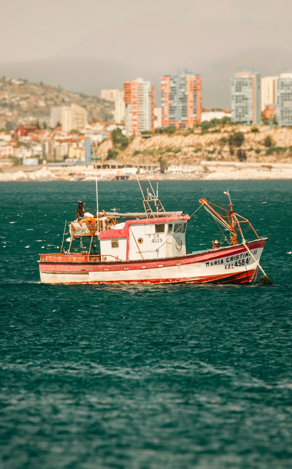 a red and white boat in the middle of the ocean