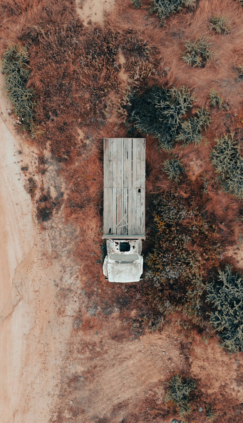 an aerial view of a truck parked on a dirt road