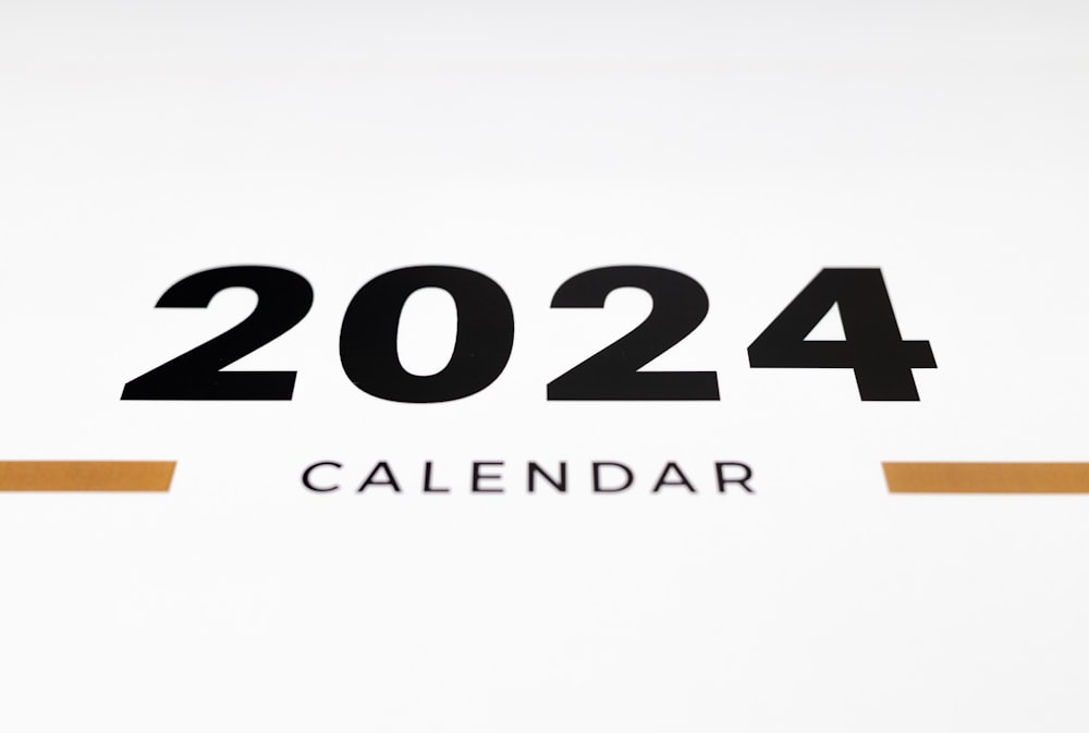 a white wall with a black and orange calendar on it